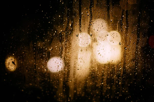 雨天车前灯的朦胧灯光在玻璃上的圆形反射 — 图库照片