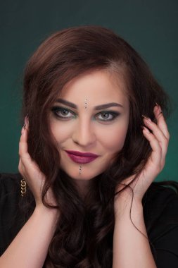 Yeşil göz gölgesi, makyaj, yüz taşı kristalleri olan bir kız.