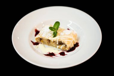 close up of delicious sweet dessert with mint leaf on a plate