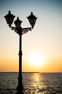 lantern on sea coast at sunset