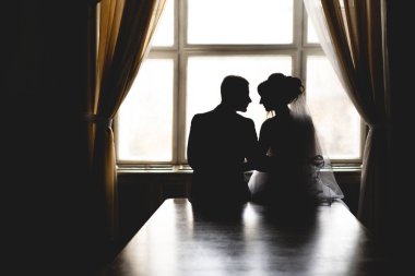 silhouette of a wedding couple in love near the window