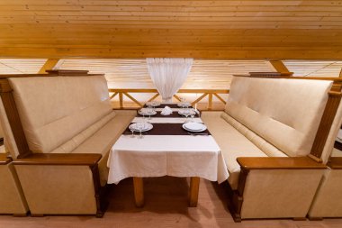 The interior of the restaurant in the style of wood, with a large table and chairs