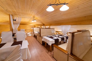 The interior of the restaurant in the style of wood, with a large table and chairs