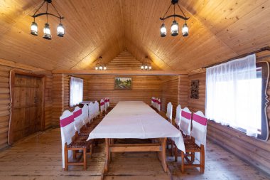 The interior of the restaurant in the style of wood, with a large table and chairs