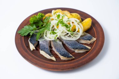 a dish of herring with potatoes on a plate