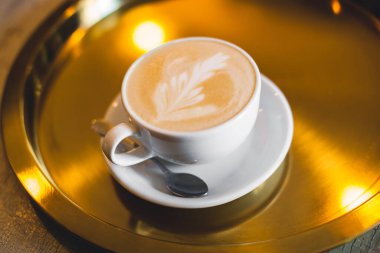 a mug of cappuccino on a tray