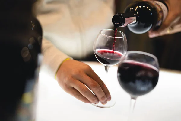 waiter pours the wine into a glass