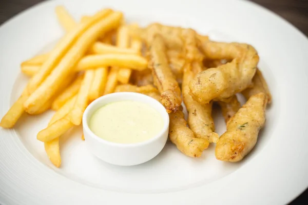 menu with fried shrimp and french fries with sauce on a plate