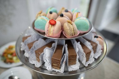 various delicious macaron cookies on a round stand tray