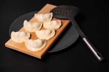 freshly prepared dumplings with kitchen utensils