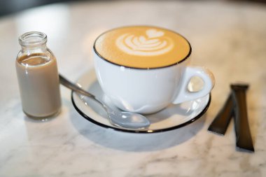a fragrant and warm mug of cappuccino with a drawing heart, on table