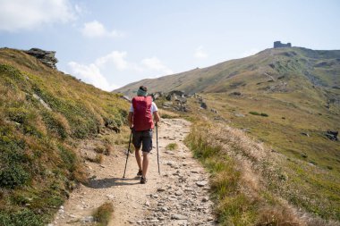 traveler with a backpack climbing to mountains