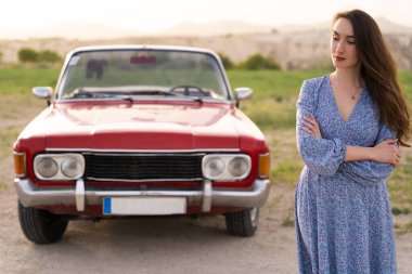 beautiful girl in retro style posing near vintage red cabriolet car