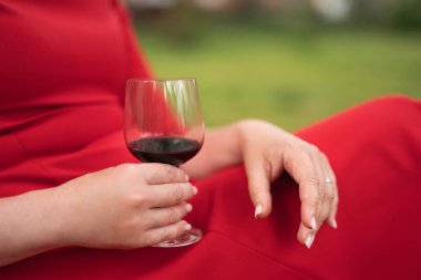 Kırmızı elbiseli bir kız ve bir bardak şarap.