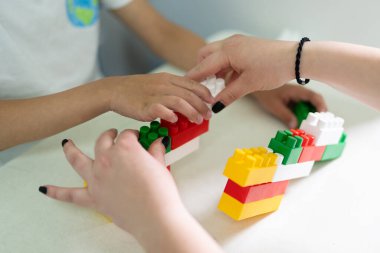 küçük bir çocuk inşa ederken bir inşaatçıyla oynar