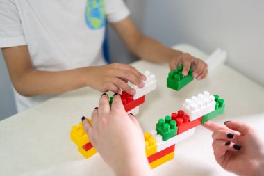 küçük bir çocuk inşa ederken bir inşaatçıyla oynar