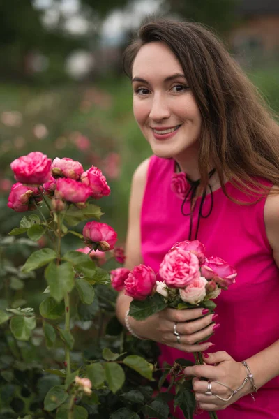 Una Hermosa Chica Vestido Rosa Está Recogiendo Rosas Rojas Jardín —  Fotos de Stock
