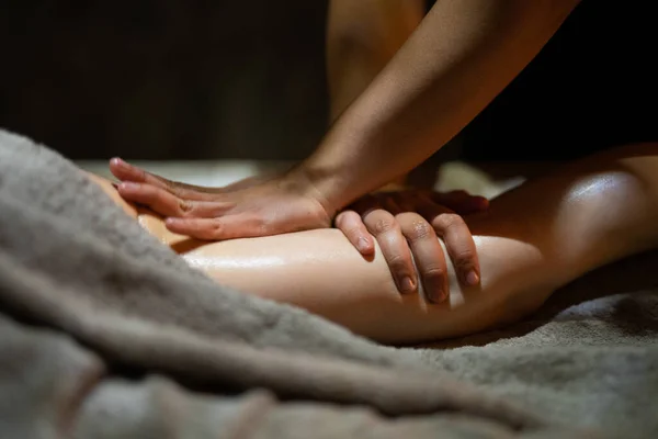 Bir masöz karanlık bir odada masaj yapar.