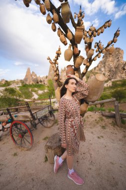 Kapadokya dağlarında elinde sürahilerle bir ağacın yanında güzel bir kız