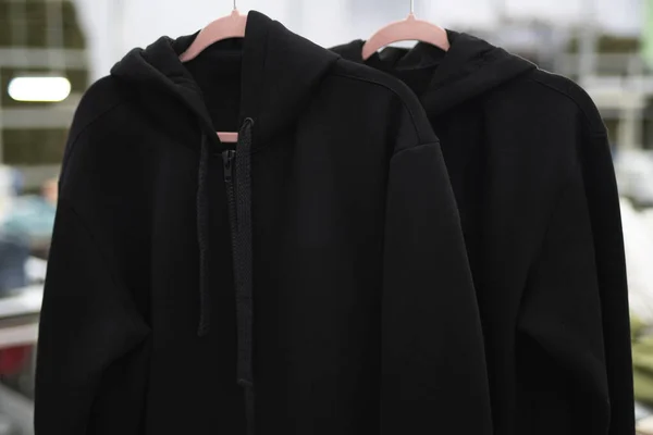 Μαύρα Ρούχα Κουκούλα Κρέμονται Από Κρεμάστρες Στο Εργοστάσιο Royalty Free Φωτογραφίες Αρχείου