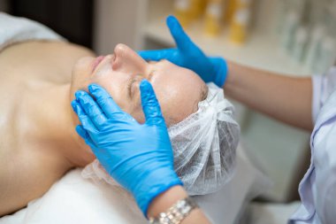 Güzellik salonunda bir adamın yüzünde estetik ameliyatlar.