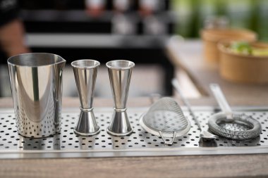 Bir barmenden alkollü kokteyl yapmak için profesyonel aksesuarlar masada.