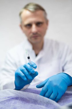 Elinde şırınga tutan bir doktorun yakın çekimi.