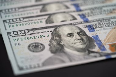 Siyah arka planda 100 dolarlık banknotlar