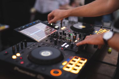 a DJ plays music on a controller at a party