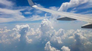 Gökyüzünde güzel, kalın bulutlar uçağın yüksekliğinden motorlu kanat manzaralı.