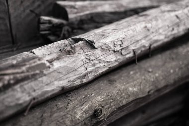 Arka bahçeye istiflenmiş eski tahta tahtaların siyah beyaz fotoğrafı.