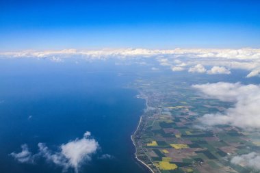 Gökyüzünde güzel, kalın bulutlar uçağın yüksekliğinden kıta ve ülkeler manzaralı.