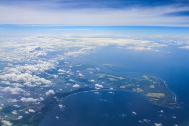 Gökyüzünde güzel, kalın bulutlar uçağın yüksekliğinden kıta ve ülkeler manzaralı.