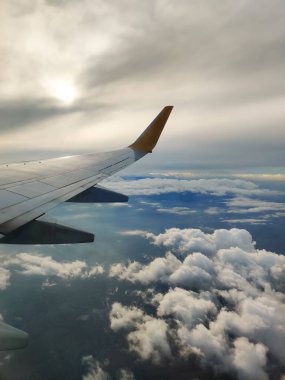 Gökyüzünde güzel, kalın bulutlar uçağın yüksekliğinden motorlu kanat manzaralı.
