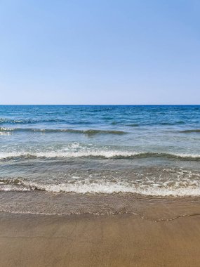 Denizin üzerinde kumlu bir sahilin güzel manzarası