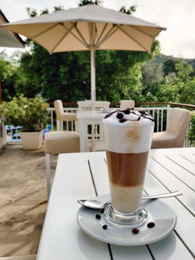 Şeffaf bir bardakta, üç katmanlı kahve fincanı.