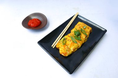 Telur dadar gulung ya da Tamagoyaki ya da Japonların Çin böreği. Gyeran Mari veya Kore usulü omlet. Sahanda yumurta beyaz arkaplanı izole eder