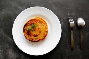 Paratha ekmeği ya da canai ekmeği ya da roti maryam, favori kahvaltı yemeği. Tabakta servis edilir.