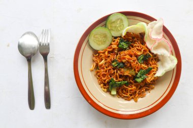 mie tek tek or fried noodle made with egg noodles with chicken, cabbage, mustard greens, meatballs, scrambled eggs. indonesian food