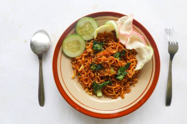 mie tek tek or fried noodle made with egg noodles with chicken, cabbage, mustard greens, meatballs, scrambled eggs. indonesian food