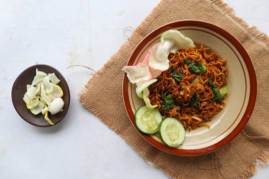 mie tek tek or fried noodle made with egg noodles with chicken, cabbage, mustard greens, meatballs, scrambled eggs. indonesian food