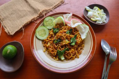 mie tek tek or fried noodle made with egg noodles with chicken, cabbage, mustard greens, meatballs, scrambled eggs. indonesian food