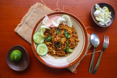 mie tek tek or fried noodle made with egg noodles with chicken, cabbage, mustard greens, meatballs, scrambled eggs. indonesian food