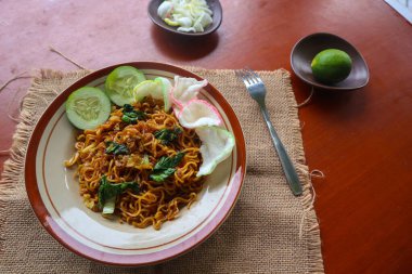 mie tek tek or fried noodle made with egg noodles with chicken, cabbage, mustard greens, meatballs, scrambled eggs. indonesian food