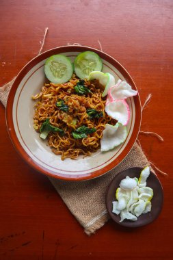 mie tek tek or fried noodle made with egg noodles with chicken, cabbage, mustard greens, meatballs, scrambled eggs. indonesian food