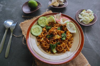 mie tek tek or fried noodle made with egg noodles with chicken, cabbage, mustard greens, meatballs, scrambled eggs. indonesian food