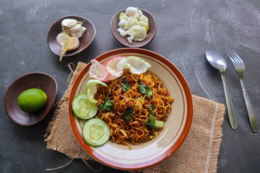 mie tek tek or fried noodle made with egg noodles with chicken, cabbage, mustard greens, meatballs, scrambled eggs. indonesian food