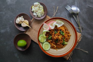 mie tek tek or fried noodle made with egg noodles with chicken, cabbage, mustard greens, meatballs, scrambled eggs. indonesian food