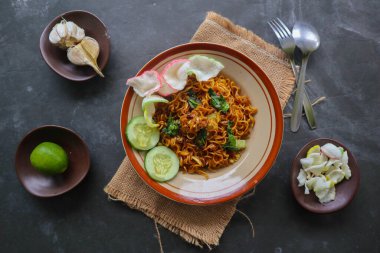 mie tek tek or fried noodle made with egg noodles with chicken, cabbage, mustard greens, meatballs, scrambled eggs. indonesian food