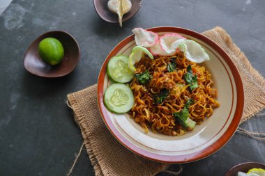 mie tek tek or fried noodle made with egg noodles with chicken, cabbage, mustard greens, meatballs, scrambled eggs. indonesian food